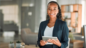 A woman smiling while holding a tablet