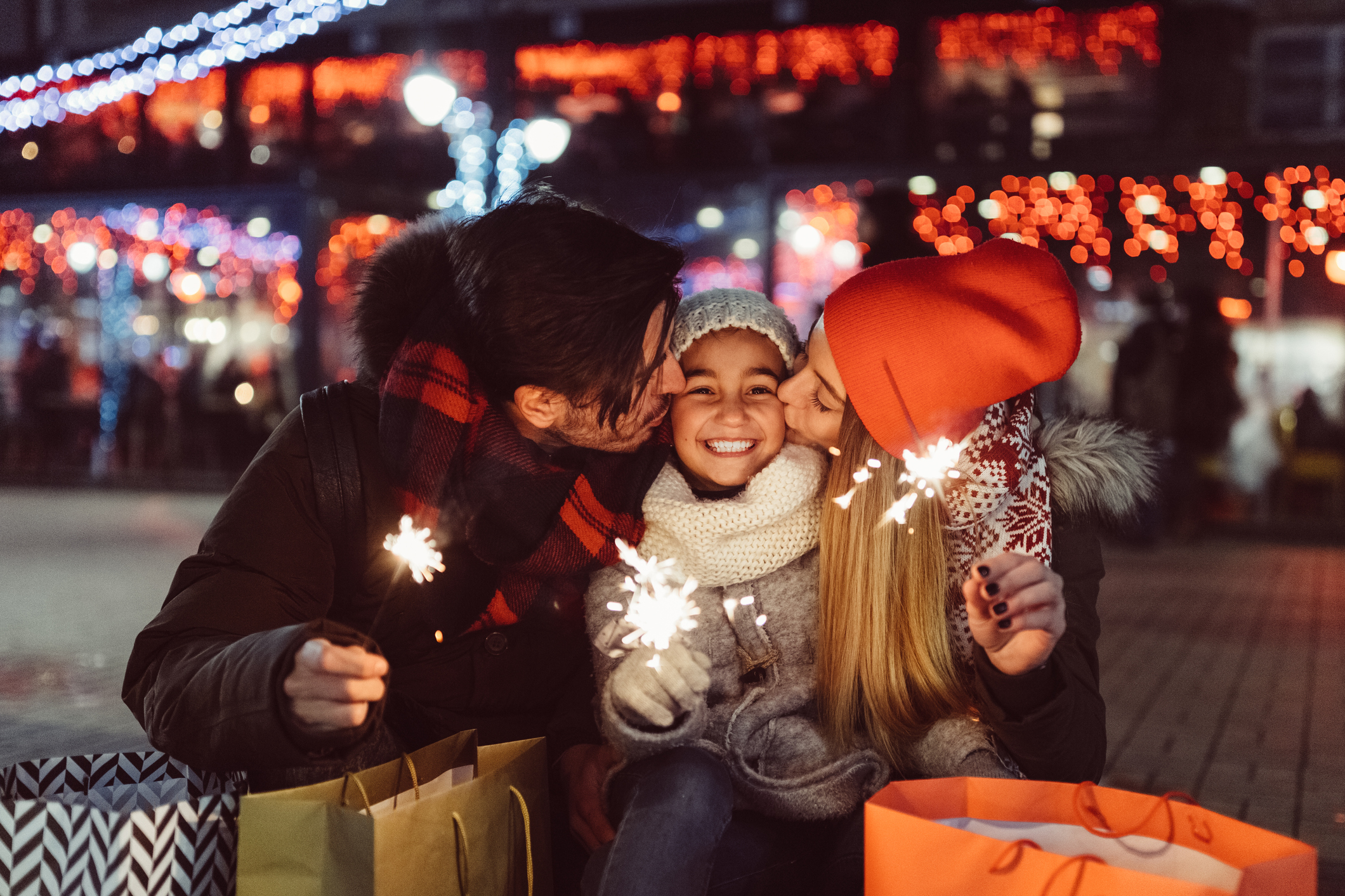 family with shopping bags and sparklers