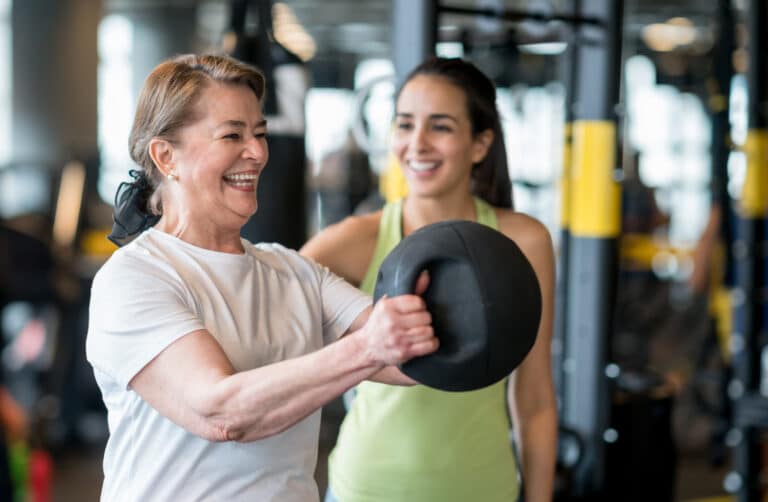 woman lifting weights with trainer