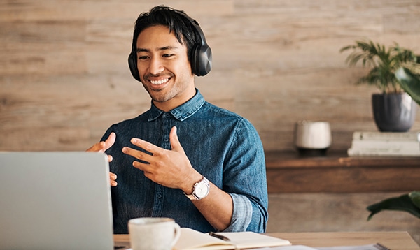 man smiling with a headset on talking with his hands