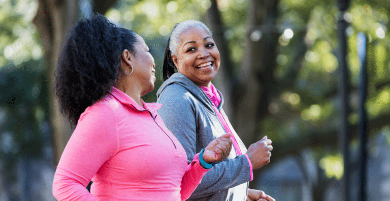 Two women smiling as they're running outdoors